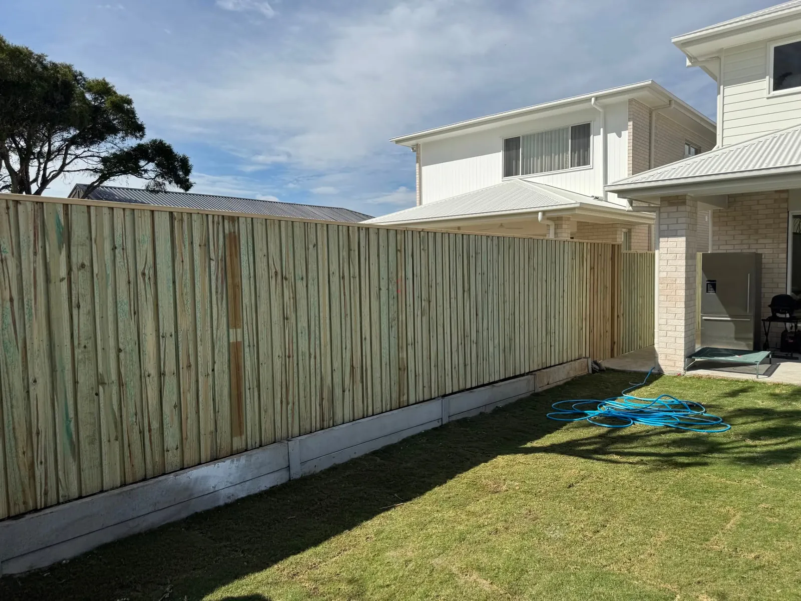 Long treated pine boundary fence beside a Wynnum home