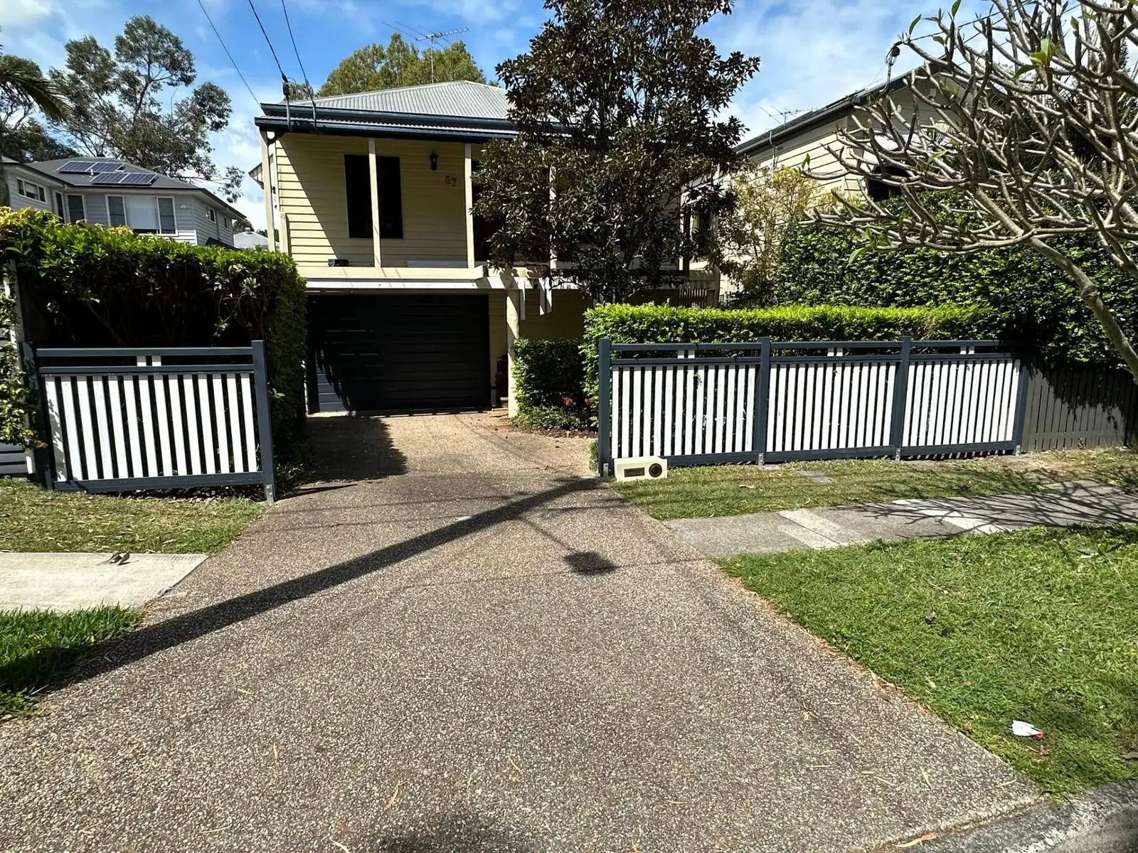 Painted timber batten front fence across the frontage of a Brisbane Queenslander