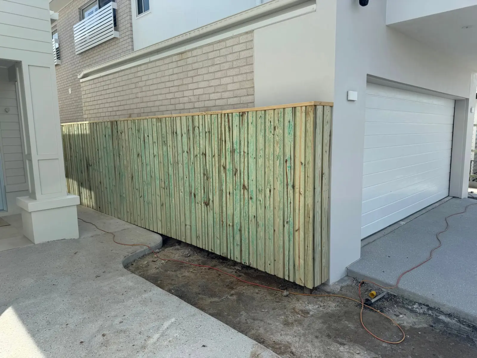 Timber screen fence built between a driveway and neighbouring wall at a Brisbane home