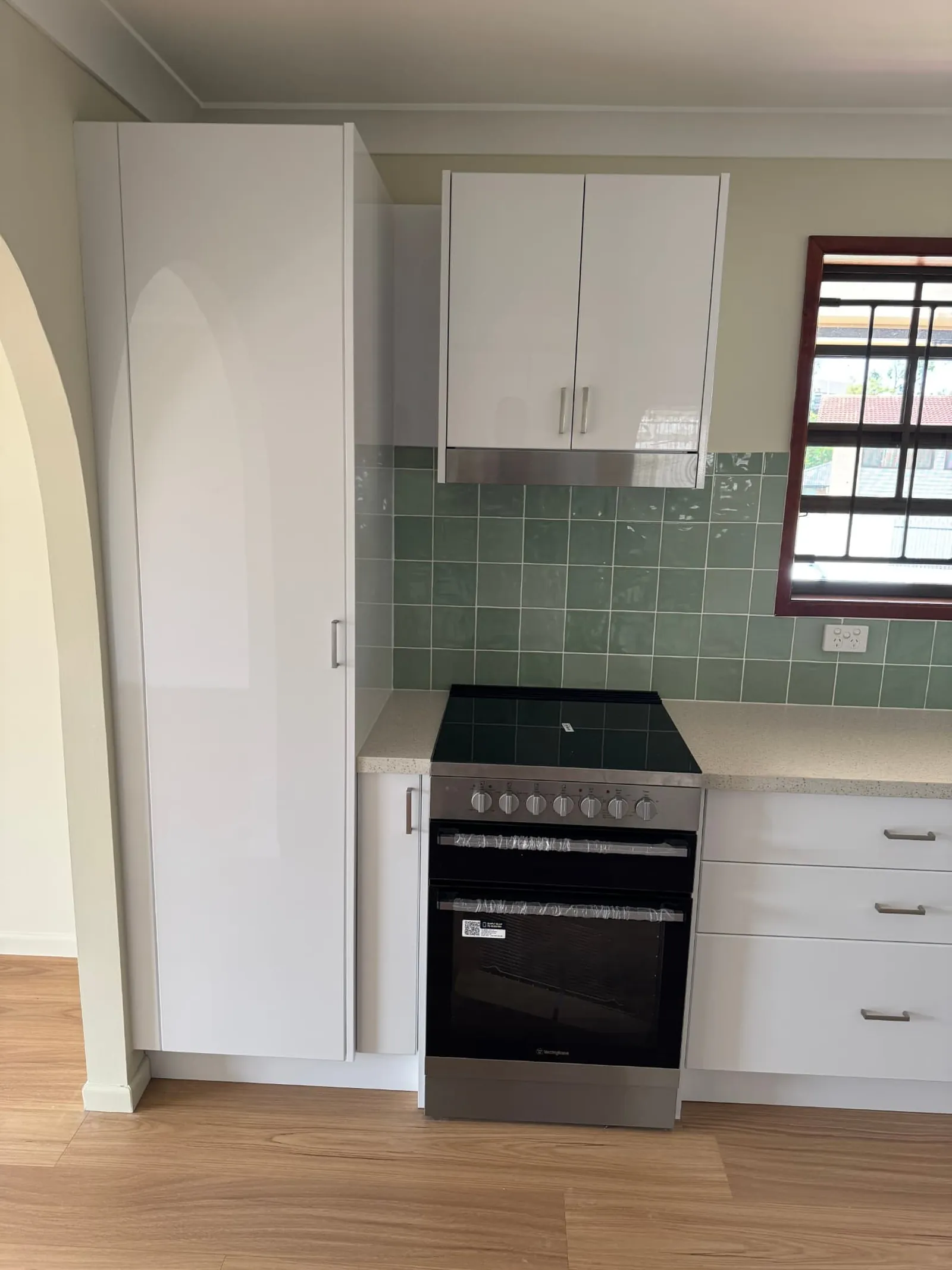 New oven, pantry cabinetry and green tiled splashback in a Carindale kitchen