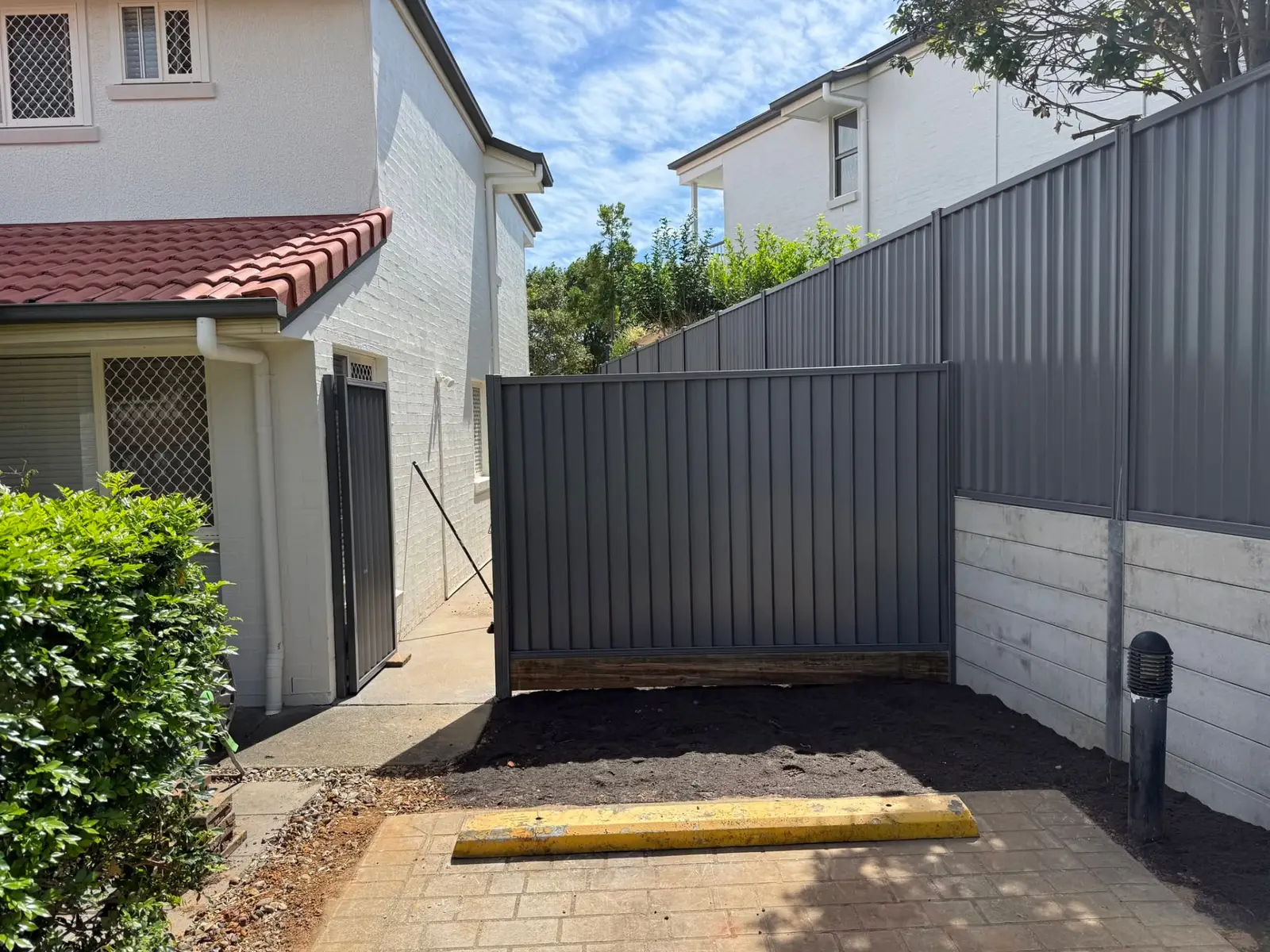 Wide Colorbond gate providing side access between two Brisbane townhouses