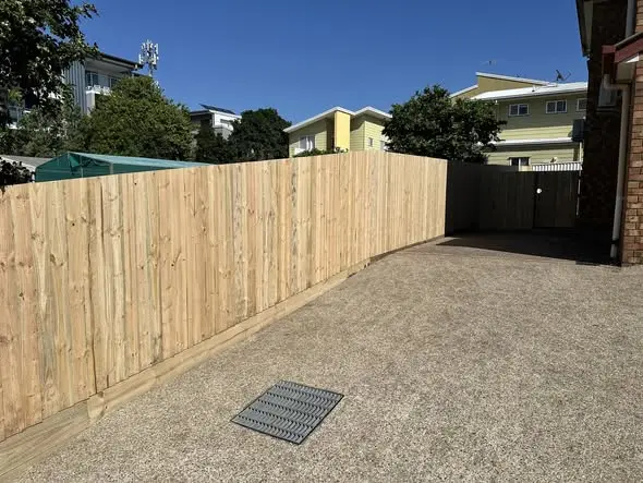 Treated pine boundary fence and gate beside a Brisbane driveway