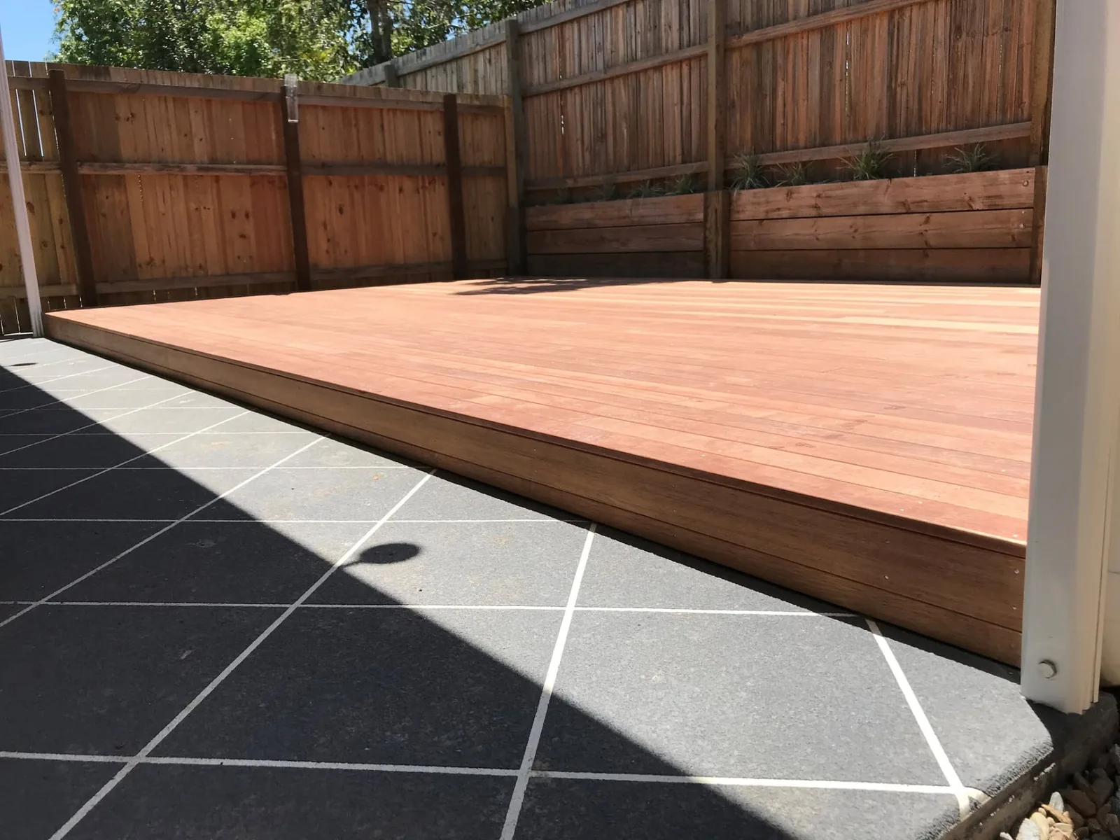 Edge detail of the hardwood deck meeting the tiled patio in Parkinson